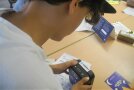 Ein Schüler versucht eine Geldkassette mit einem Code zu öffnen
