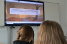 Im Klassenzimmer wird ein Text an die Wand projeziert