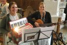 Zwei Frauen sitzen mit Musikinstrumenten in der Kirche