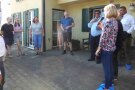 Personen stehen auf einem Hof vor einem Haus