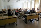 Personen sitzen im einem Klassenzimmer
