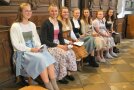 Frauen im Dirndl sitzen in einer Kirche