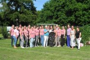Personen stehen für ein Gruppenfoto auf einer Wiese