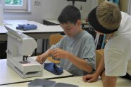 Zwei Schüler sitzen vor einer Nähmaschine