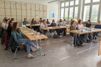 Personen sitzen in einem Klassenzimmer