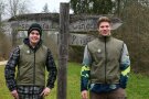 Zwei Personen vor einem Schild im Wald