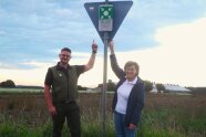 Ein Mann und eine Frau stehen vor einem Verkehrszeichen