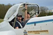 Zwei Personen sitzen in einem kleinen Motorflugzeug